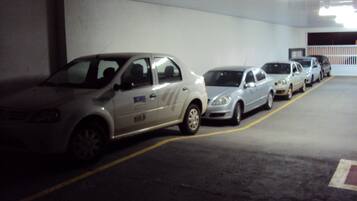 Uma garagem de estacionamento com vários carros estacionados em fila.