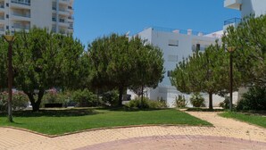 Un quartier résidentiel avec des bâtiments modernes, un chemin pavé et de nombreux arbres.