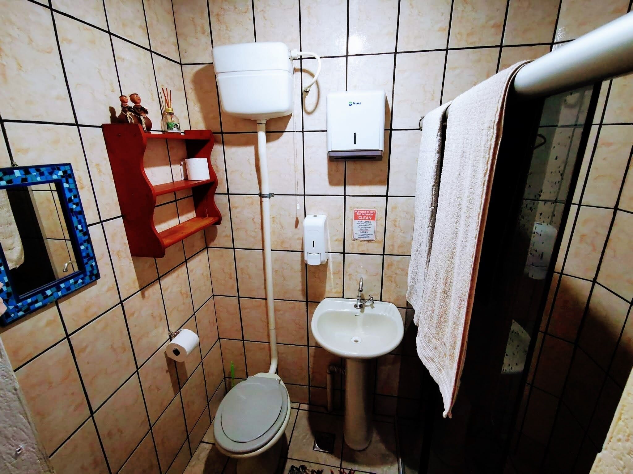 A small bathroom with a toilet, sink, and a towel rack.