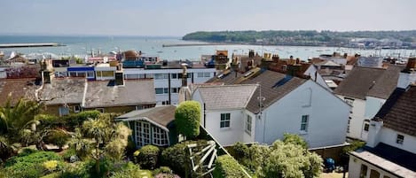 A coastal residential area with houses, a marina, and a clear view of the sea.