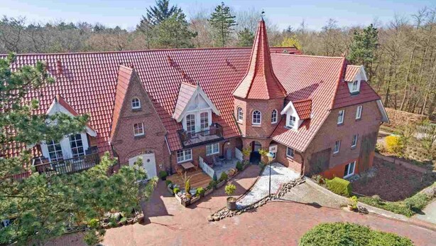 A large, multi-story building with a red-tiled roof and a prominent central tower. - Apartment "Flounder" (ID 344) - Friesenresidence (Sankt Peter-Ording)