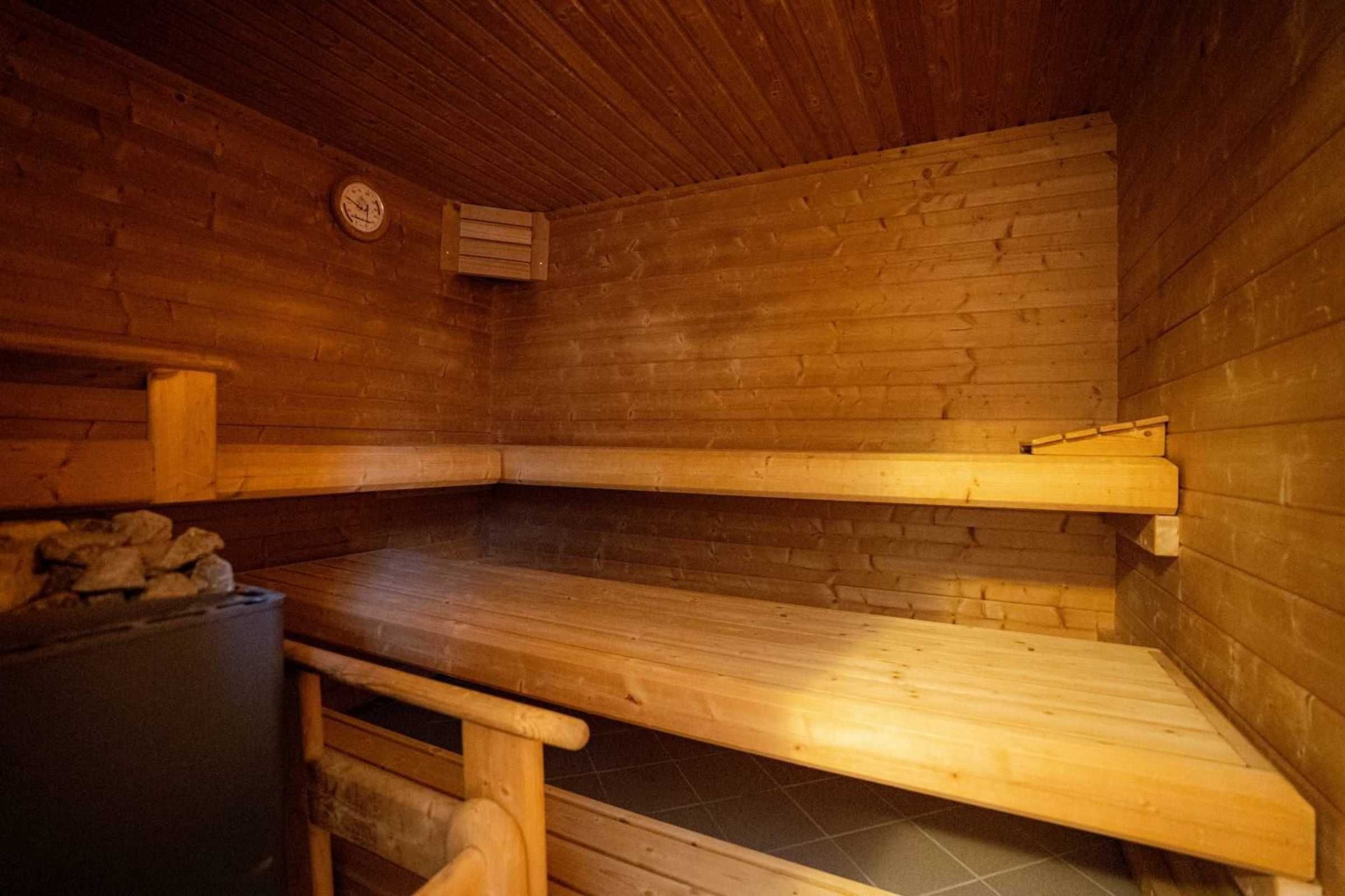 Un sauna con bancos de madera y piso de baldosas.