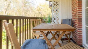 A wooden deck with a table and chairs, a brick wall, and a lattice screen. - Apartment "Flounder" (ID 344) - Friesenresidence (Sankt Peter-Ording)