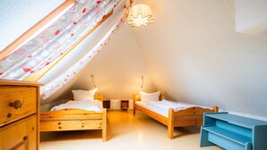 A small, cozy room with two wooden beds, a desk, and a ceiling fan. - Apartment OG (ID 313), Germany (Sankt Peter-Ording)