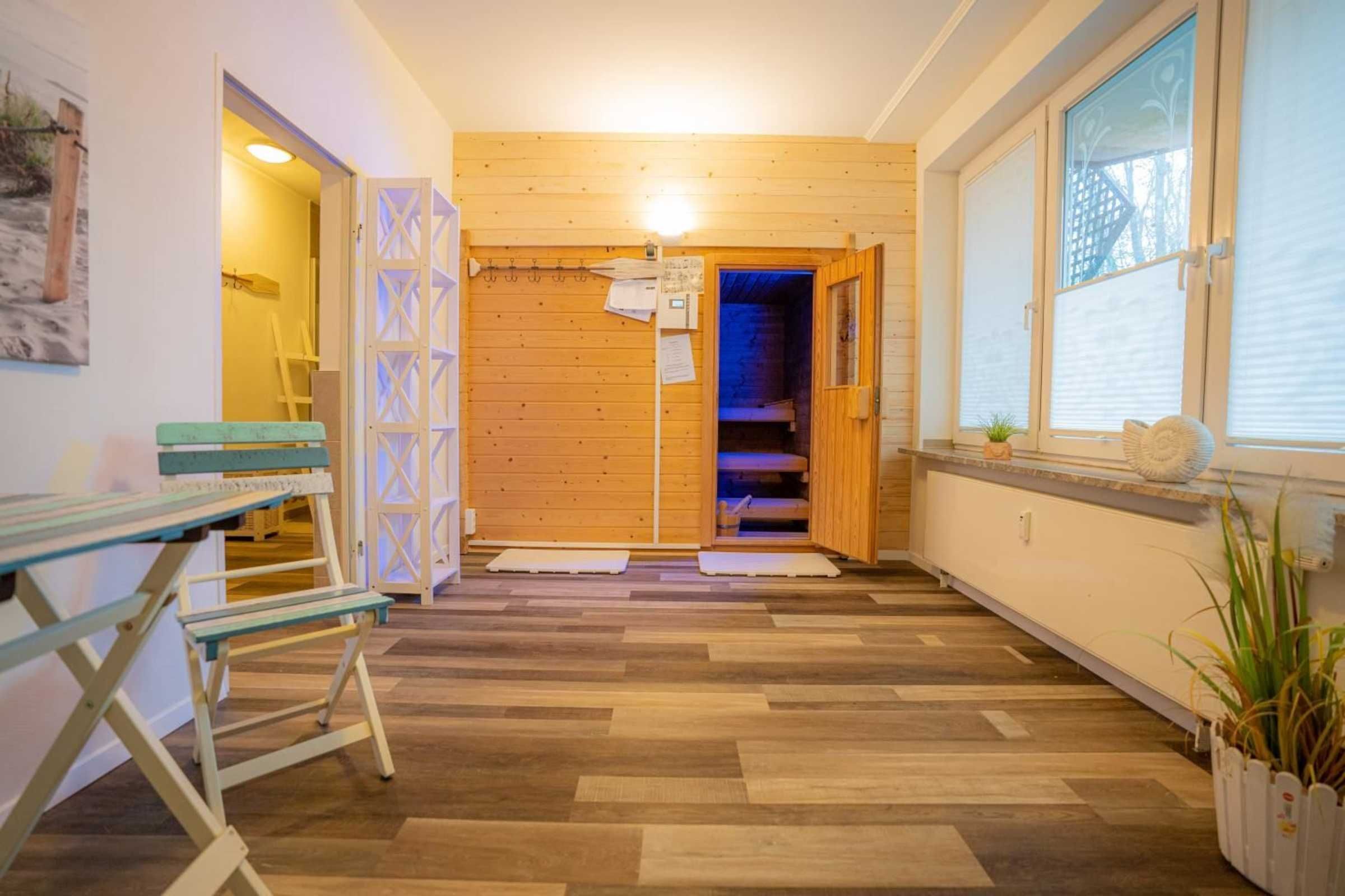 Un intérieur en bois avec un banc, une petite table et une plante en pot.