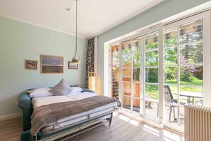 Un dormitorio con cama, un ventanal y vistas al exterior.