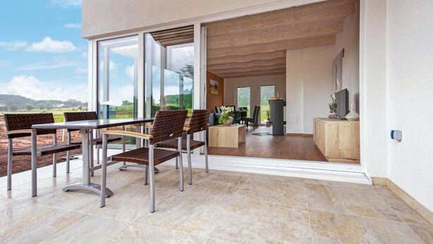 A modern outdoor dining area with a view of the countryside. - Ferienhaus 1 Wolfschlucht (Prüm OT Walcherath)