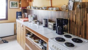 Cozinha com fogão, cafeteira e diversos utensílios.