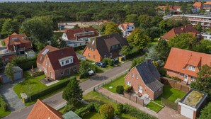 An aerial view of a residential area with houses, roads, and greenery. - House part 19 (ID 032) - House Nordlys (Sankt Peter-Ording)