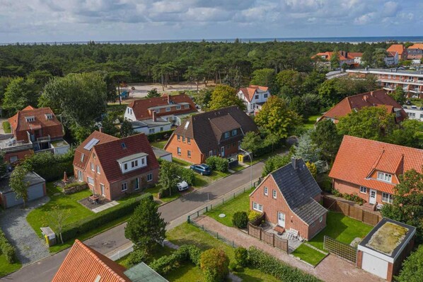 An aerial view of a residential area with houses, roads, and greenery. - House part 19 (ID 032) - House Nordlys (Sankt Peter-Ording)