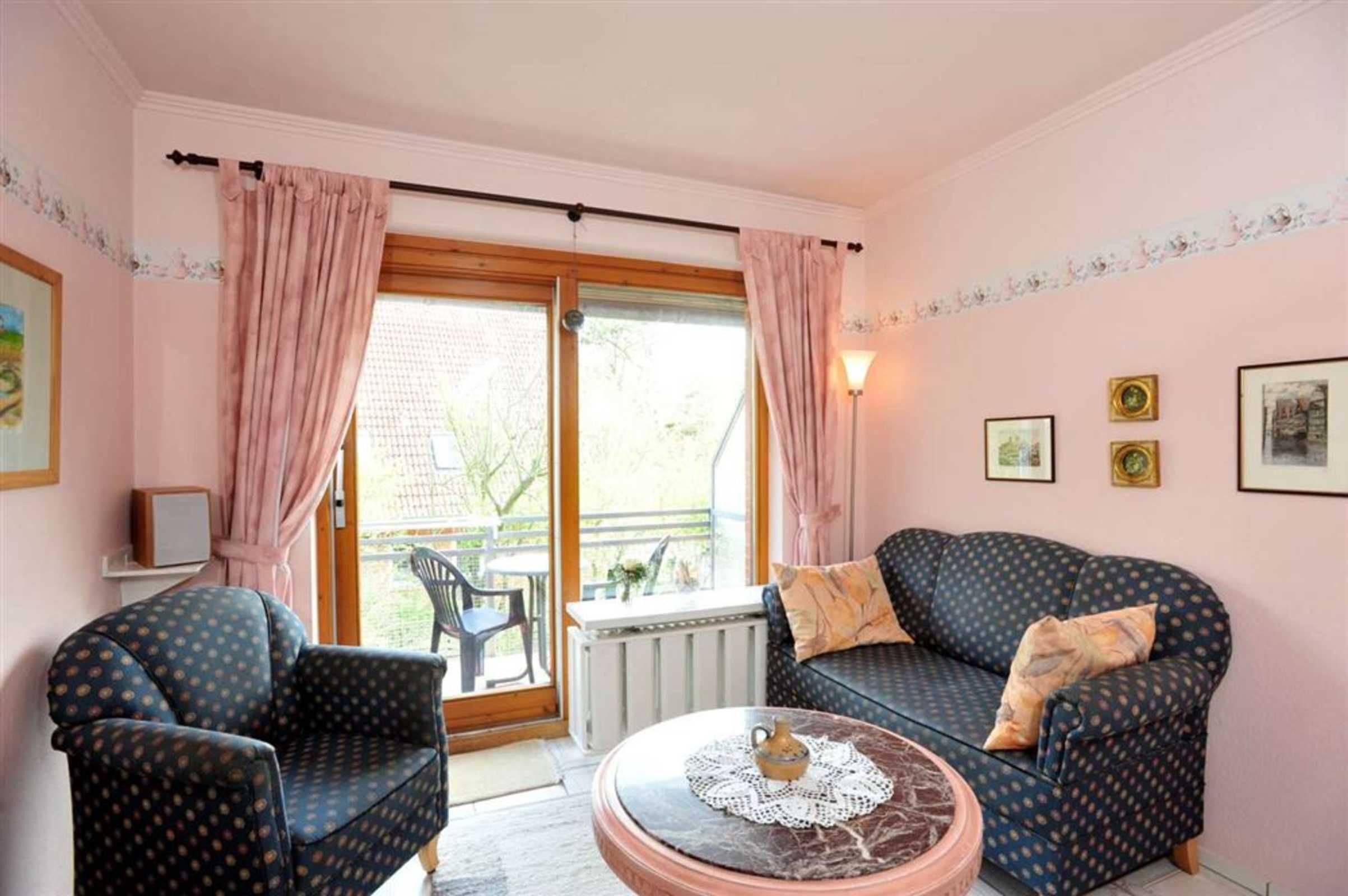 A cozy living room with a sofa, armchair, and a coffee table.