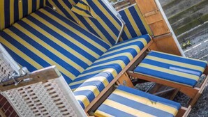 Une chaise longue de plage avec un revêtement rayé bleu et jaune.