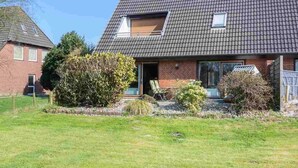 Une maison à deux étages, dotée d’un toit en pente, d’un petit porche à l’avant et d’une fenêtre bien visible.