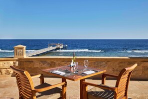 A table with chairs and a view of the ocean. - JAZ Grand Marsa - All inclusive (El Quseir)