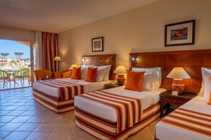 A hotel room with two beds, a view of the pool, and a dining area with chairs. - JAZ Grand Marsa - All inclusive (El Quseir)