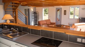 A kitchen with a built-in stove, a sink, and a wooden counter. - Homerez - House in Sauzon (Sauzon)