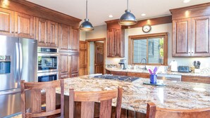 A kitchen with wooden cabinets, stainless steel appliances, granite countertops, and a large island with seating. - Spacious. Private Hot Tub.Views. Deck. Pool Table. (Breckenridge)