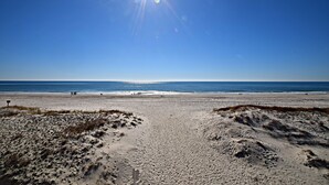 Une plage avec un ciel dégagé et un soleil éclatant.