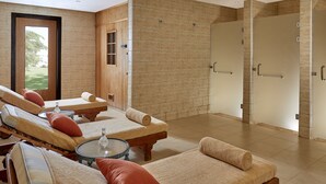 A spa area with massage chairs, a glass table, and a large window.