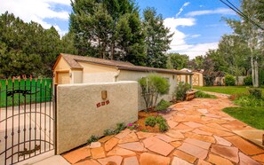 Stroll through the serene garden to the charming house with an entrance.