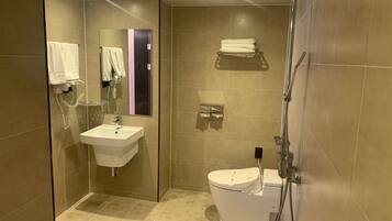A modern bathroom with a sink, toilet, and shower.