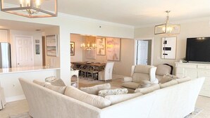 A modern living room with a sectional sofa, a dining area, and a TV.