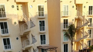 Ein Resort mit Swimmingpool, einem Gebäude mit Reetdach und einem mehrstöckigen Gebäude mit Balkonen.