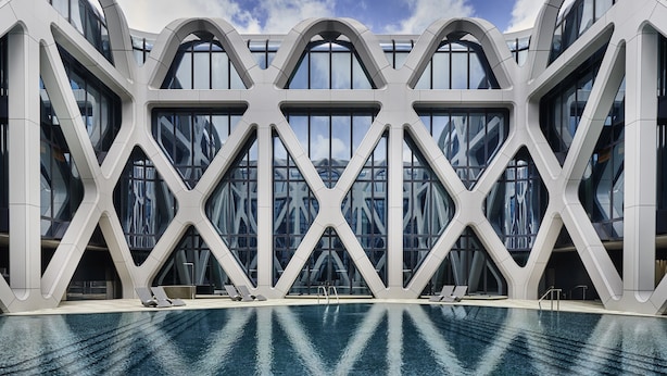 Un edificio moderno con piscina y diseño arquitectónico geométrico.