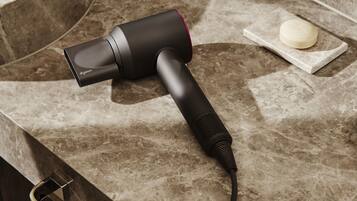 A Dyson hair dryer on a marble countertop.