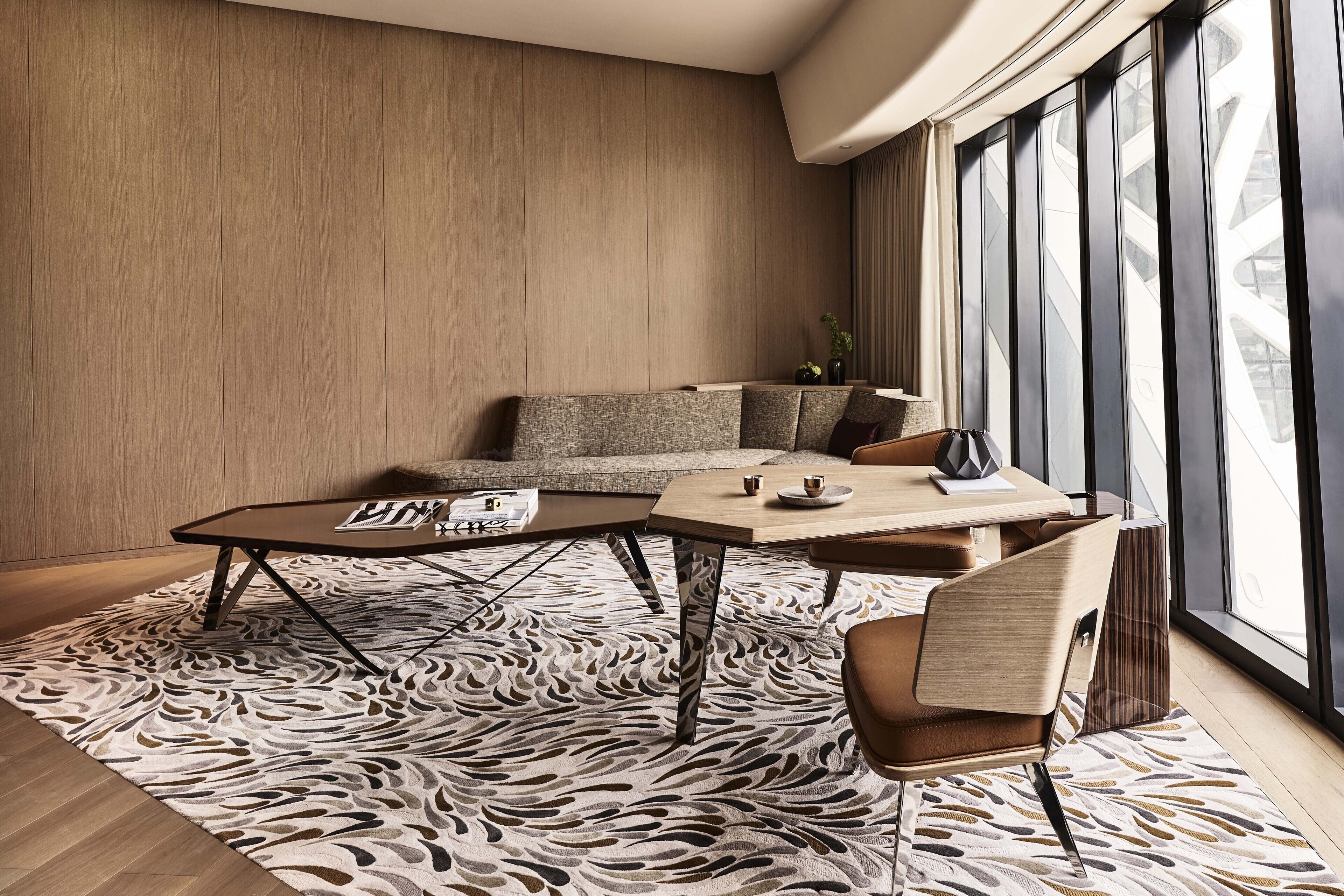 Een moderne woonkamer met een bank, een salontafel en een uitzicht op een gebouw door grote ramen.