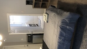 Un dormitorio pequeño con cama, un escritorio y una ventana.