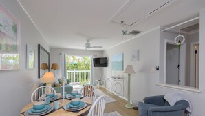 A dining area with a wooden table set for four, white chairs, and a blue and white color scheme.