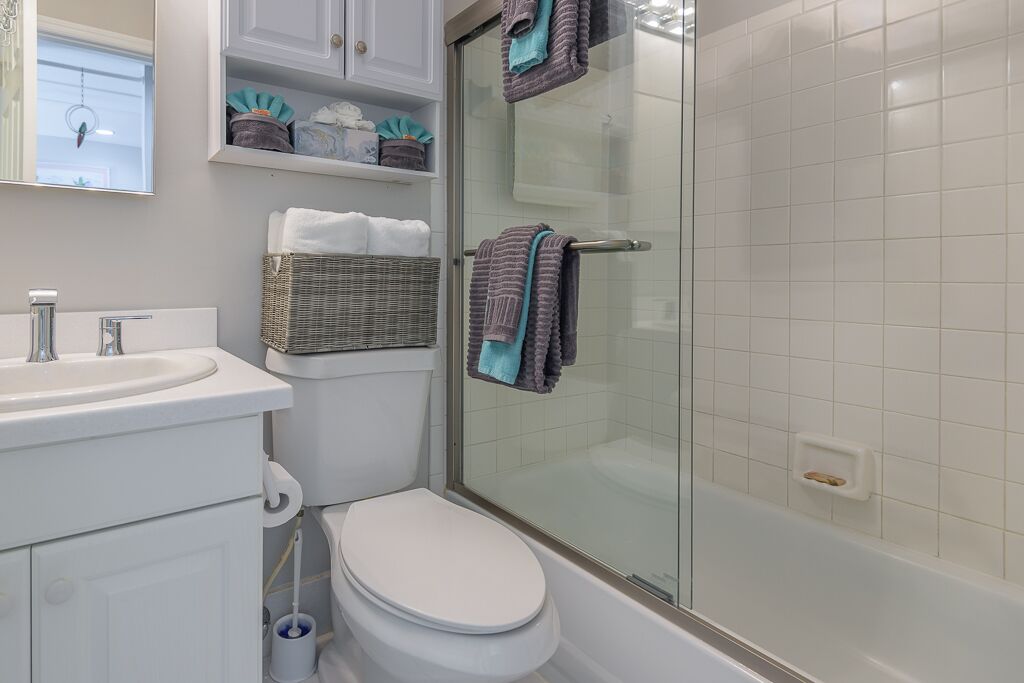 Een badkamer met toilet, wastafel en douche.