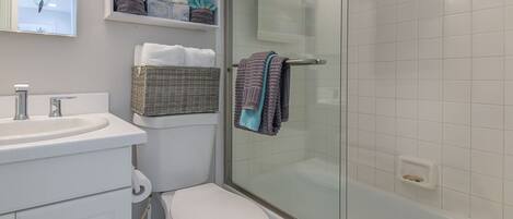 Een badkamer met toilet, wastafel en douche.