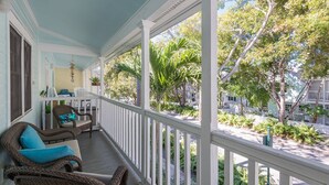 A porch with wicker furniture and a view of a residential street.
