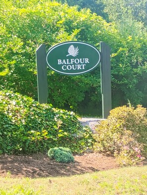 A sign for Balfour Court with a logo, surrounded by greenery. - WALK TO RESTAURANTS, SHOPS & LIQUOR STORE! CLOSE TO DOWNTOWN CHATHAM! (Chatham)