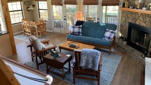 A cozy living room with a sofa, chairs, a coffee table, and a fireplace.