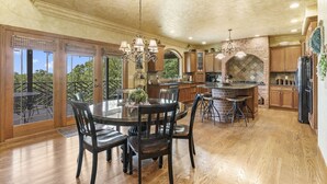 A spacious kitchen with a large island, wooden cabinets, and a brick backsplash.