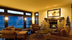 Un salón acogedor con chimenea, ventanas amplias y asientos cómodos.