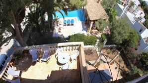 A rooftop terrace with a pool, lounge chairs, and a table. - Ses Sivines – Traditional Mallorcan Villa with Private Pool, Free WiFi and Air C (Porto Colom)