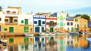 A waterfront with colorful buildings and boats docked along the shore. - Ses Sivines – Traditional Mallorcan Villa with Private Pool, Free WiFi and Air C (Porto Colom)