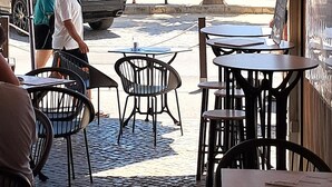 An outdoor seating area with tables and chairs, a covered section with a view of the ocean, and a parked car in the background. - MiraPraia 7- Refurbished, Air Conditioning, Wifi, TV, Bedroom and Living Room, Sea View (Quarteira)