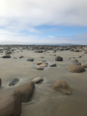 A beach with large rocks scattered across the sand. - Pretty Cottage in Louisburgh a perfect location to explore The Wild Atlantic Way (Louisburgh)