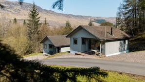 A small cabin with a sloped roof, a porch, and a front door. - Deerstalker. Beautiful 5 star, 1 bedroom chalet sleeps up to 2 (Crianlarich)