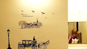 Una pared con una ilustración antigua de un carruaje tirado por caballos y un farol de la calle.