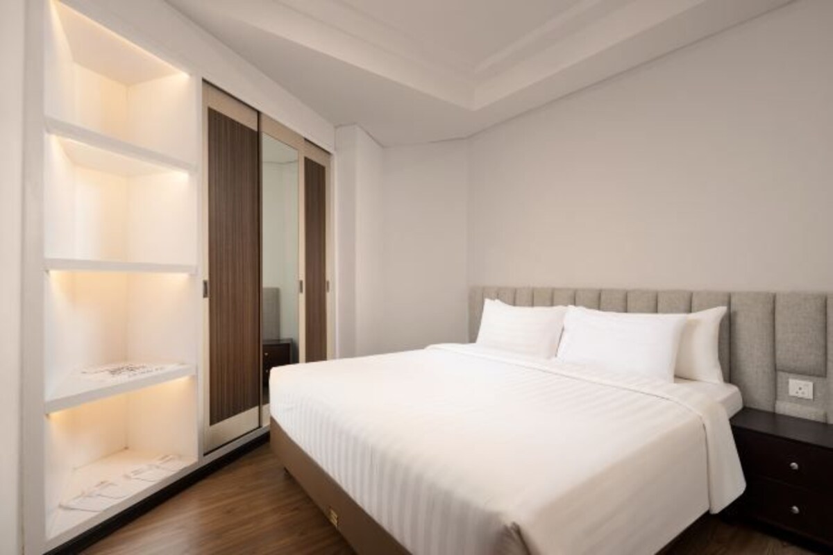 Un dormitorio con cama, armario y mesita de noche.