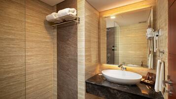 A modern bathroom with a marble sink, a towel rack, and a large mirror.