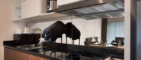 Una cocina moderna con encimera negra, electrodomésticos de acero inoxidable y muebles de madera.