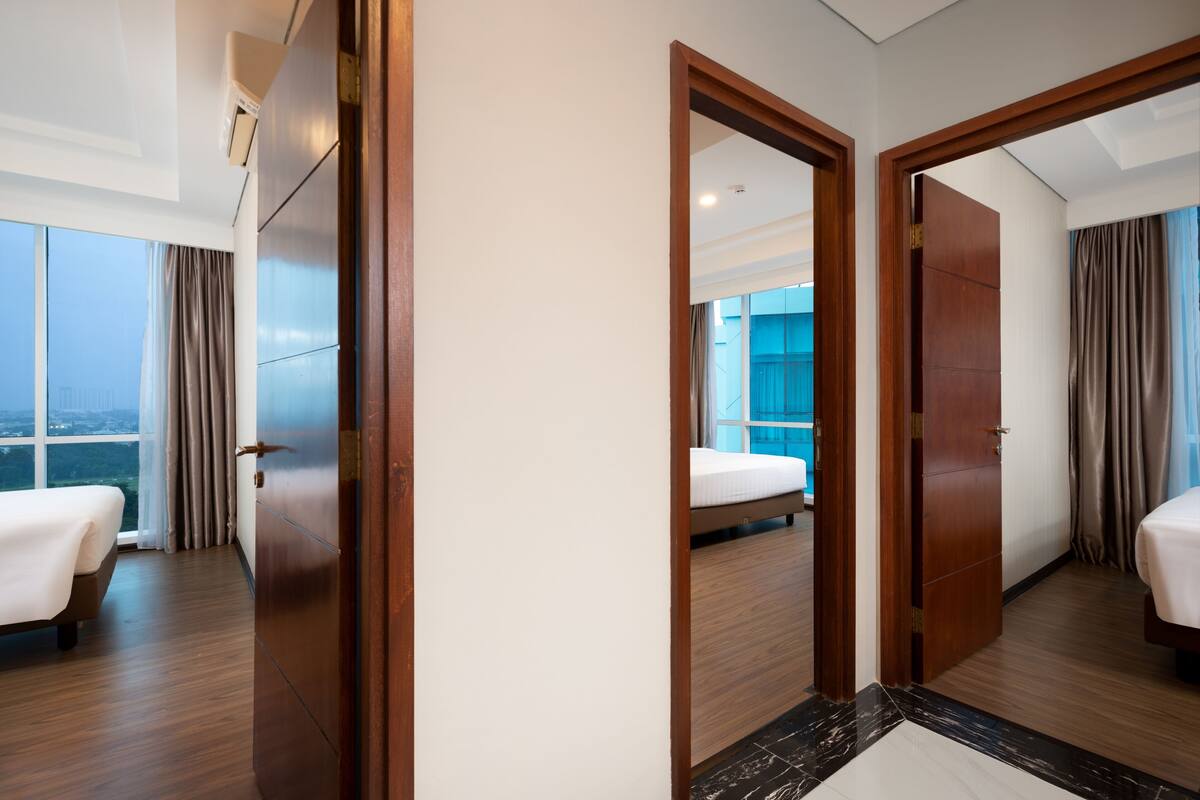 Habitación de hotel con una cama grande, un armario y vistas a la ciudad.