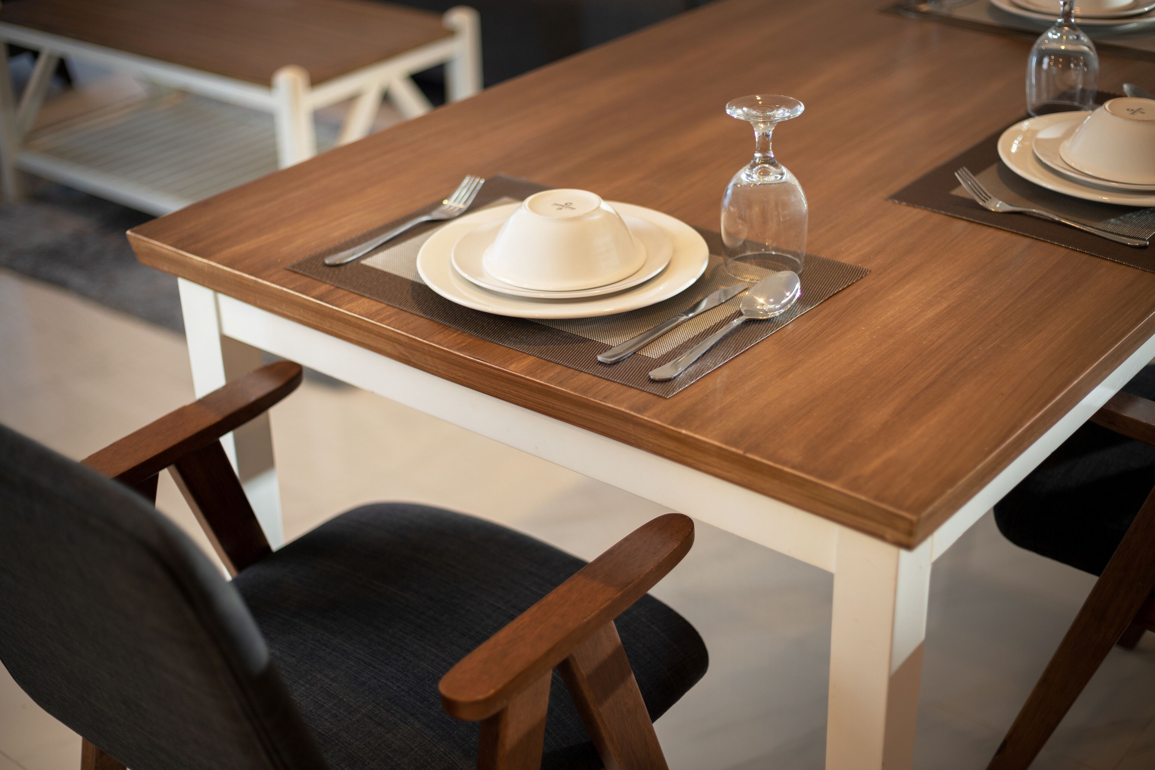 A dining table set with plates, cutlery, and a glass.